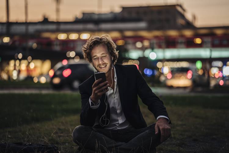 Smiling businessman relaxing with his mobile phone